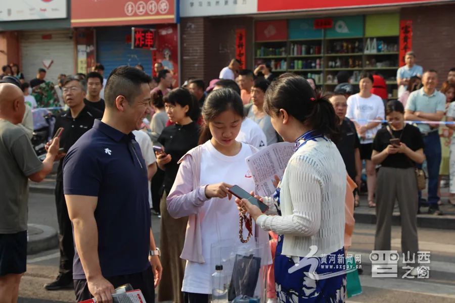 家长为即将进入考场的孩子加油、打气。