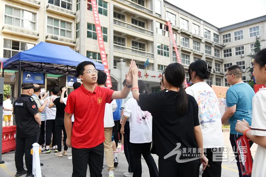 老师与考生击掌鼓劲。