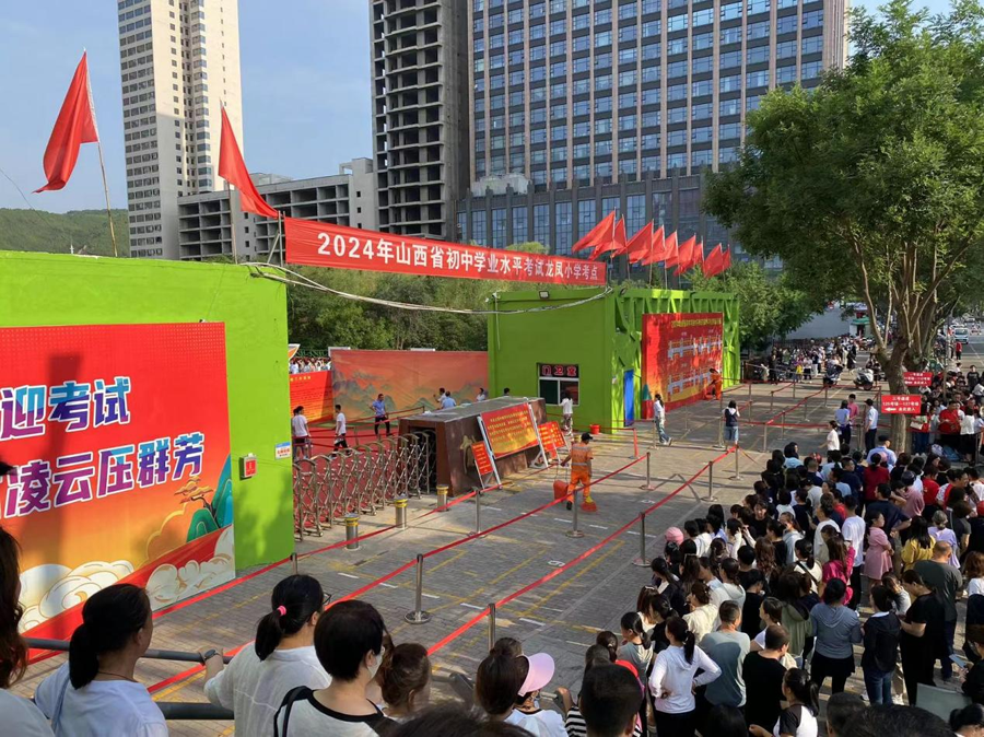 吕梁市离石区龙凤小学考点外，考生家长扎堆等待。