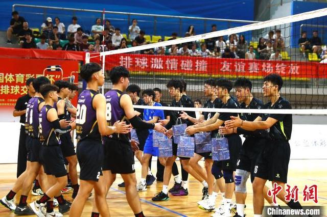 图为赛前,南昌大学男子排球队球员(右侧)向来自台湾高校的男子排球队