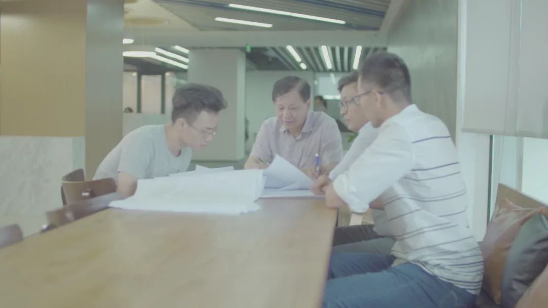 △徐士龙（左二）与团队成员讨论技术实施方案。（图片由受访者提供）