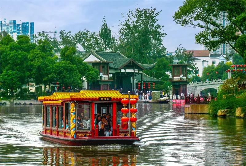 2008年10月3日,游人乘坐画舫在白鹭洲公园游玩观景.