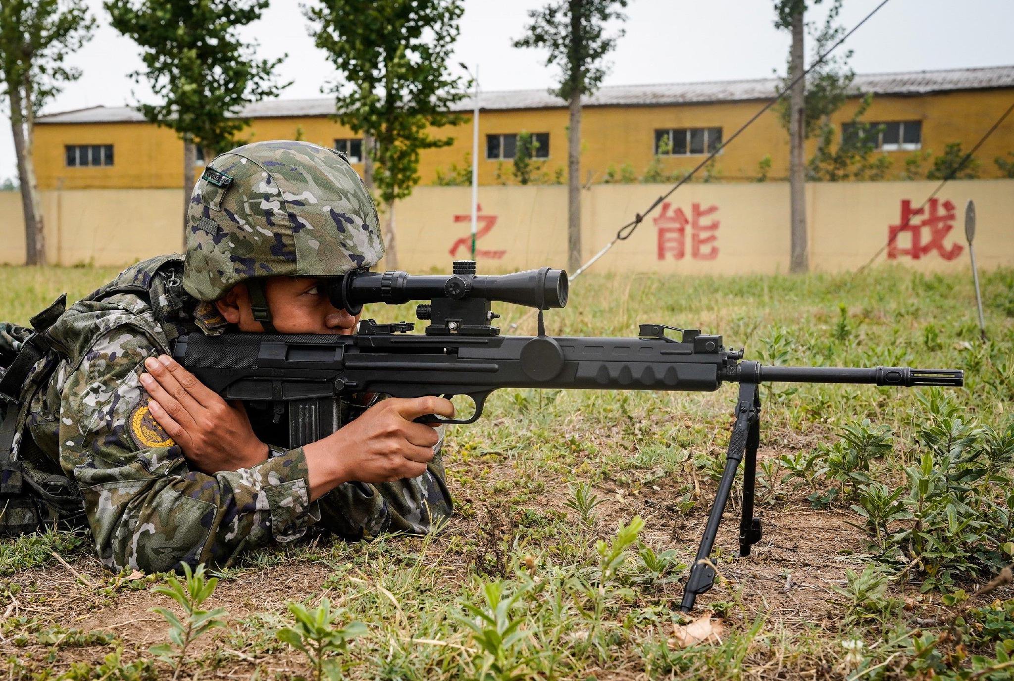 图为参考官兵进行狙击步枪对隐现目标射击