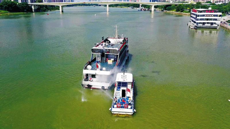 救援力量对“起火”的游船进行“救援”。(莫丽平 摄)