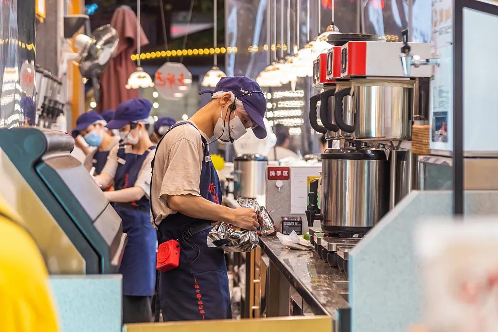 2022年9月,武汉某家茶颜悦色门店内一边制作奶茶一边喊口号的店员.