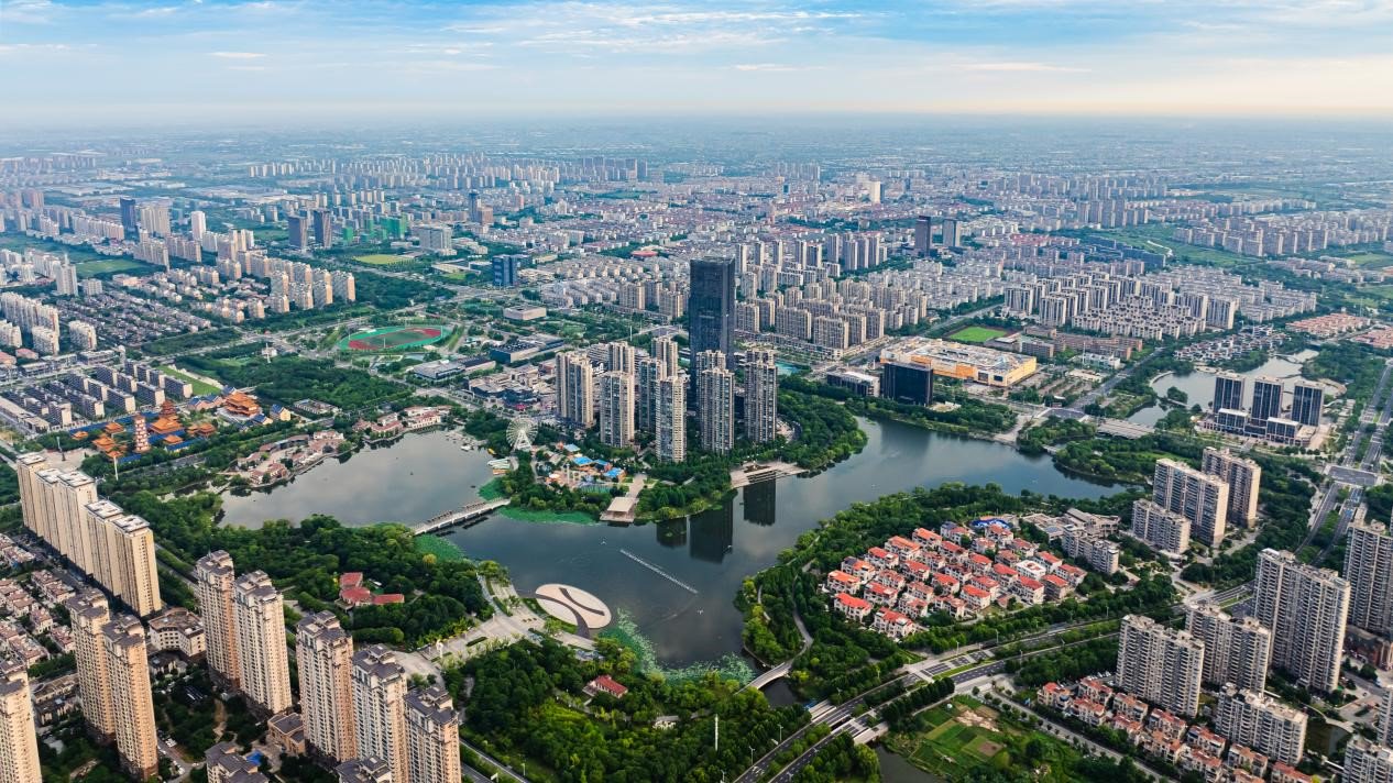 航拍南通市通州区,南山湖公园与城市建筑相映成景,碧波荡漾,绿意盎然