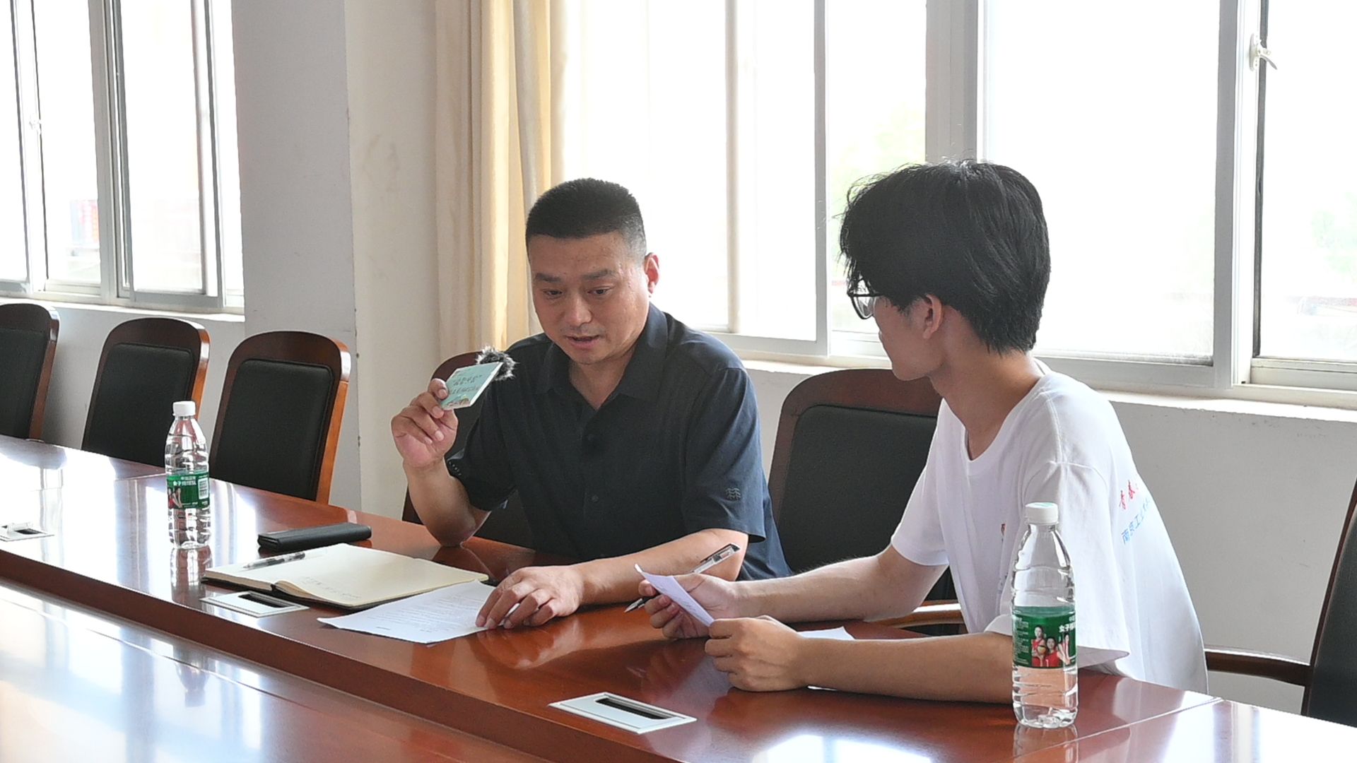 (图为实践团成员何睦访谈海头镇海前村党支部书记王金港)