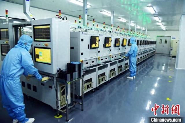 图为南昌高新区兆驰半导体有限公司生产车间,工作人员正在进行参数