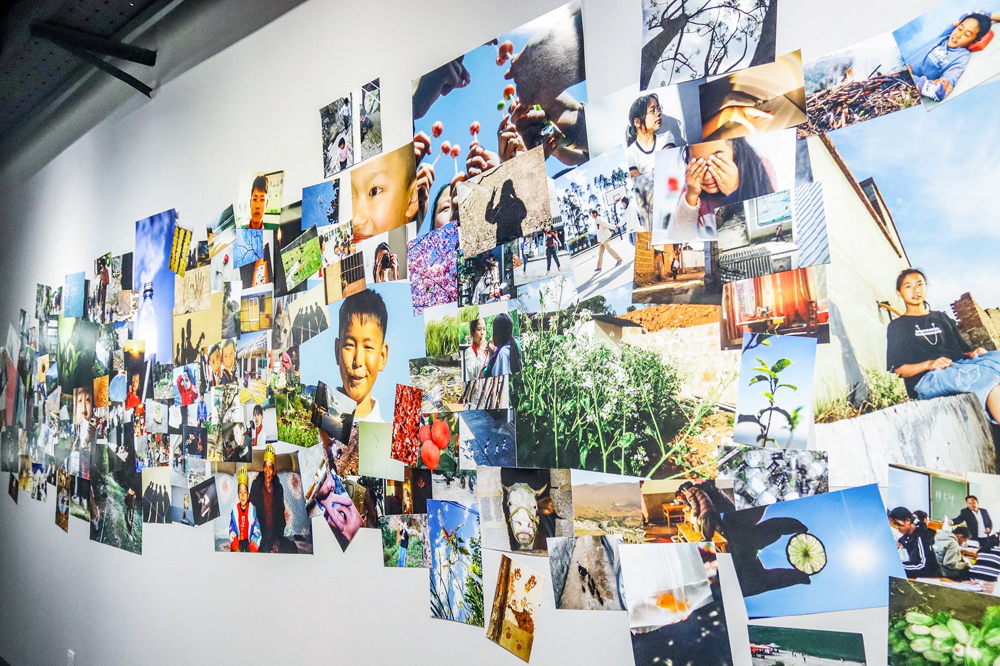 展览现场一面展示孩子作品的相片墙