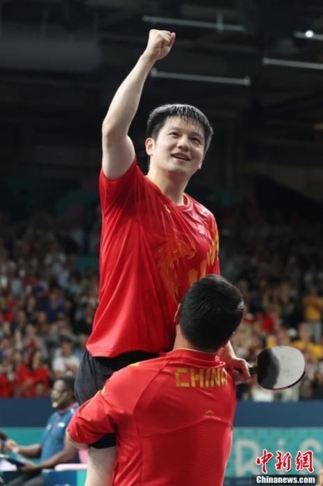 (赛后王皓高高抱起樊振东。中新社记者 富田 摄)