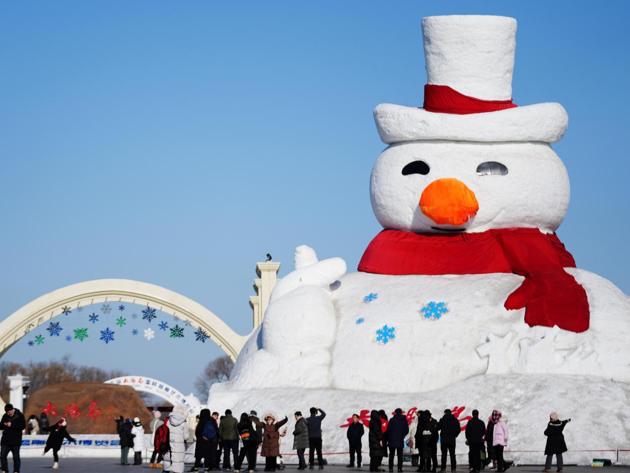 游客在太阳岛雪博会园区门口的大雪人旁拍照。新华社记者王建威 摄