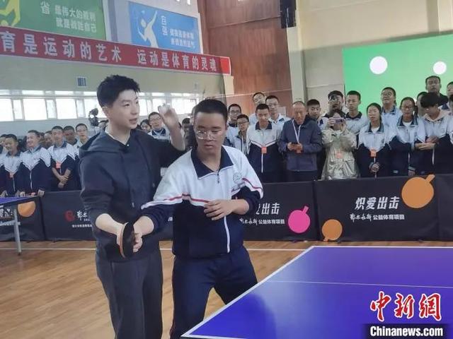 图为马龙手把手教授鄂尔多斯东胜一中学子如何握拍。李爱平 摄