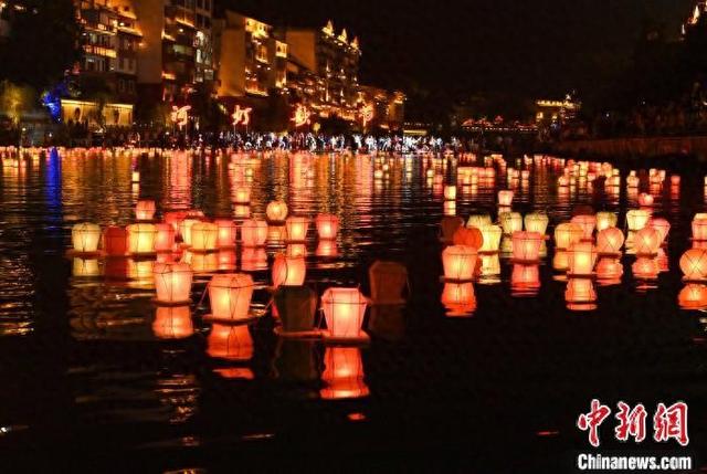 图为8月16日晚,在广西桂林市资源县资江里漂流的河灯.唐梦宪 摄