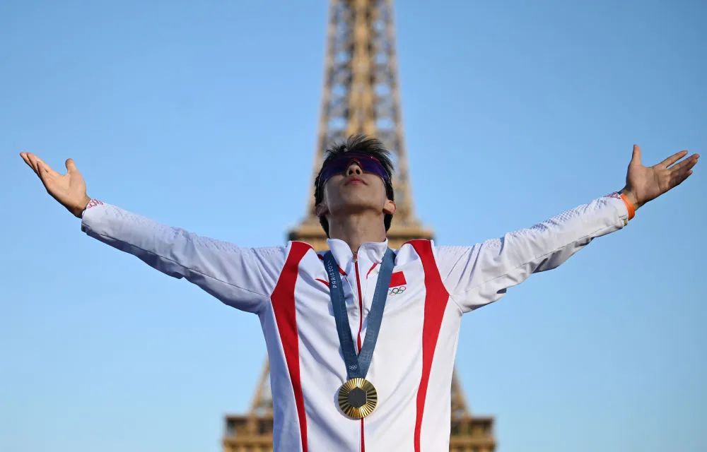 8月5日,跳水男子双人3米板金牌得主,中国选手龙道一在埃菲尔铁塔前