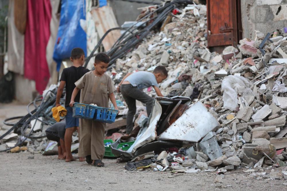 9月3日，孩子们在加沙地带中部努赛赖特难民营的一处建筑废墟搜寻物品。新华社发（马尔万·达乌德摄）