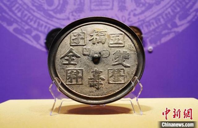 图为展览展出的明代《福寿双全五子登科铭文镜》.中新社记者 安源 摄