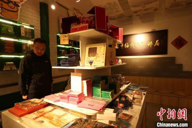 10月2日，国庆黄金周第二天，北京中轴线吸引游客。图为游客在中轴线邮局了解中轴线文创产品。中新社记者 张祥毅 摄