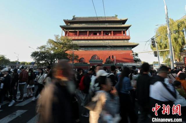 10月2日，国庆黄金周第二天，北京中轴线吸引游客。图为游客在鼓楼游览。中新社记者 张祥毅 摄