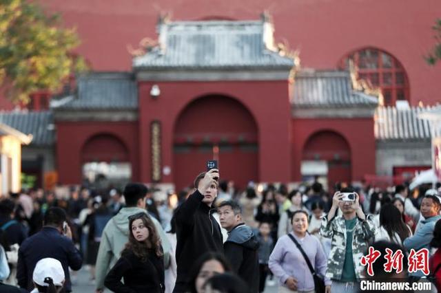 10月2日，国庆黄金周第二天，北京中轴线吸引游客。图为游客在鼓楼游览。中新社记者 张祥毅 摄