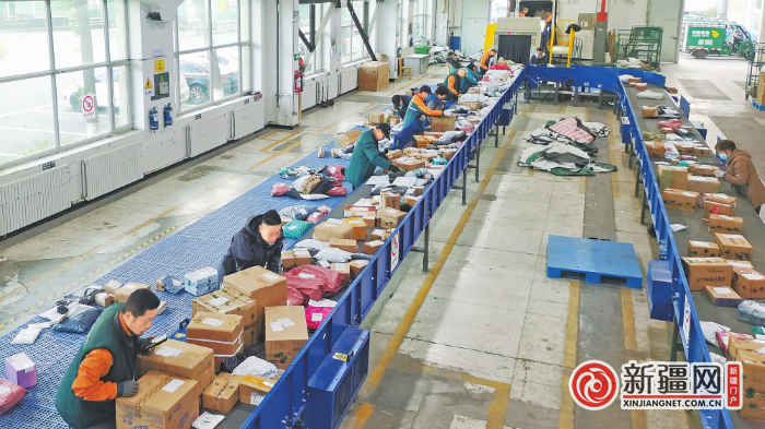 10月5日，中国邮政集团有限公司乌鲁木齐市分公司卫星广场揽投部快递员正在分拣当日到达的快递。（全媒体记者王璇摄）