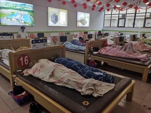 ▲9月24日,可喜安郑州凌云路店内,老人们躺在治疗仪上进行体验。新京报记者 程亚龙 摄