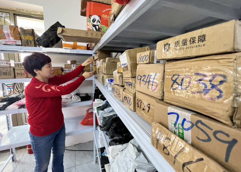 图说:新疆消费者到家附近的村快递代收点领取快递.摄影:刘洲