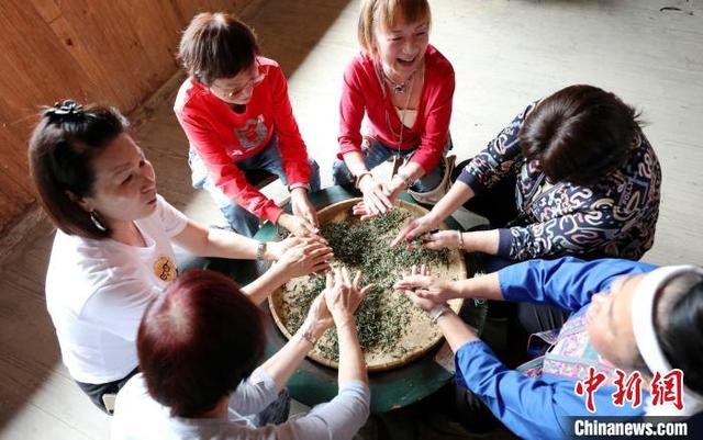 图为游客在体验炒茶。龚普康 摄