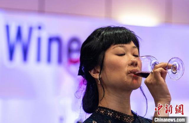 图为一位女士在发布会现场品鉴红酒。中新网记者 侯宇 摄