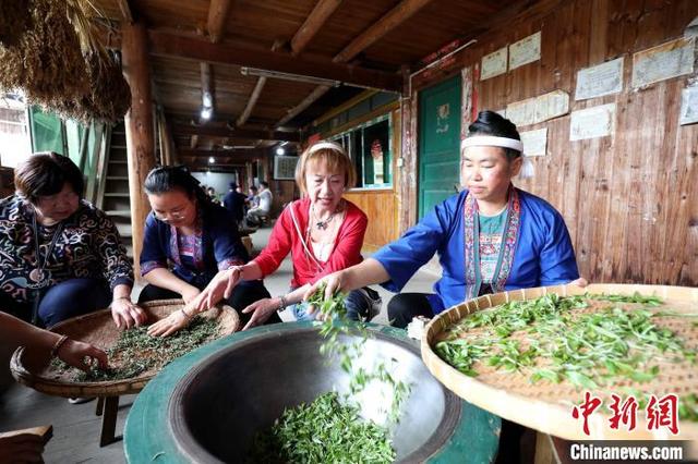 图为游客在体验炒茶。龚普康 摄