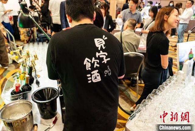 图为发布会现场的一家参展商正在准备酒水。中新网记者 侯宇 摄