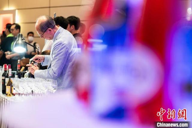 图为发布会现场一名参展商正在开瓶准备迎接品鉴者。中新网记者 侯宇 摄