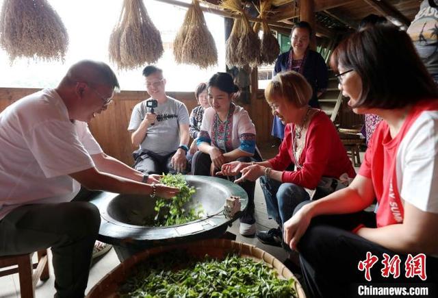 图为游客在体验炒茶。龚普康 摄