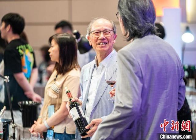 图为一名参展商(右二)和品鉴者交流。中新网记者 侯宇 摄