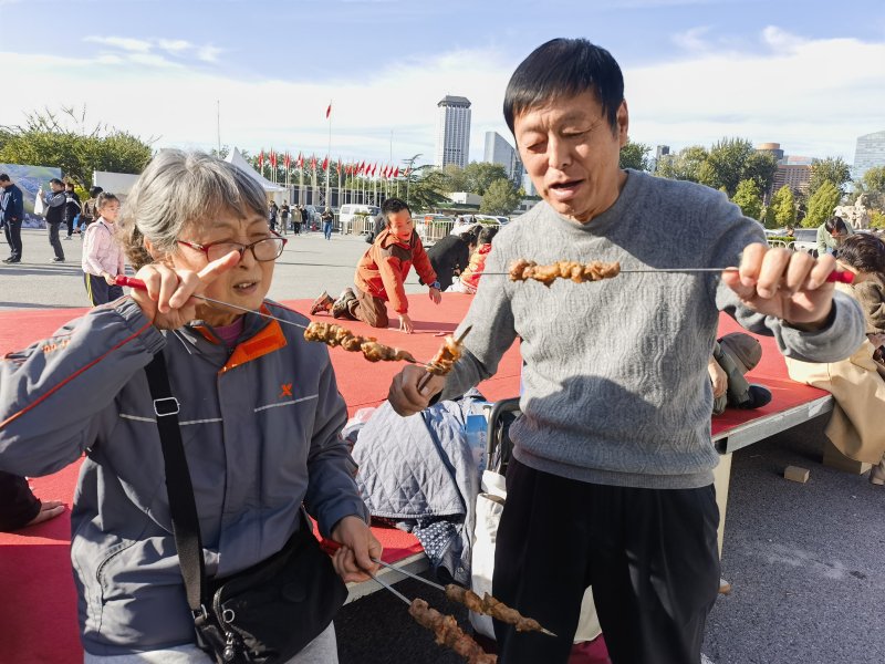 北京市民品尝和田烤羊肉串。古哈尔尼沙·依明 摄