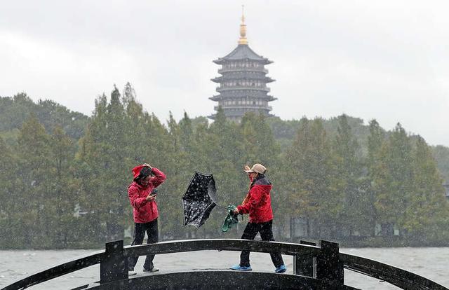 11月1日，浙江杭州，受台风“康妮”影响，杭州迎来强降雨天气，西湖景区里游客冒雨前行。视觉中国供图