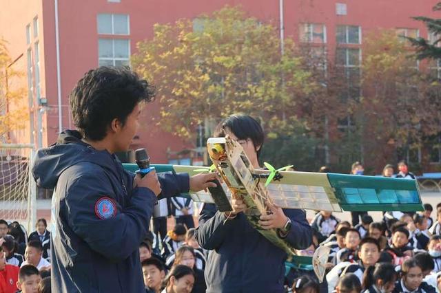 两名北京航空航天大学航模队队员向学生们讲解航模的构造。刘晨光/摄