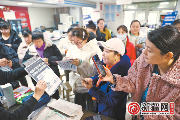 11月20日，在高新区（新市区）喀什东路街道新兴社区，辖区居民正在通过手机扫码了解家电优惠信息。 （全媒体记者石磊摄）