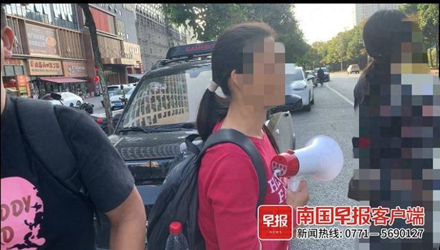 杨女士手持喇叭寸步不离地跟着张女士。南国早报全媒体记者 黄乒宾摄