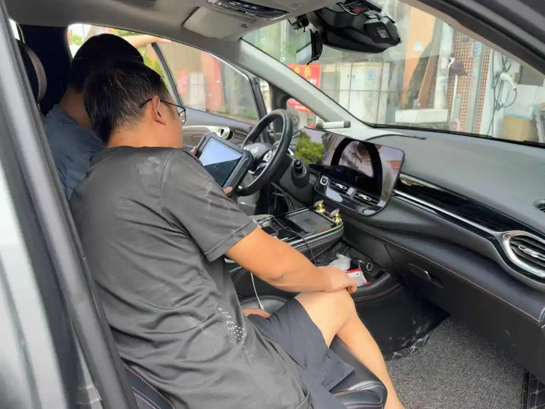 （汽修工在检查一辆广汽埃安的故障问题，《21汽车》摄）