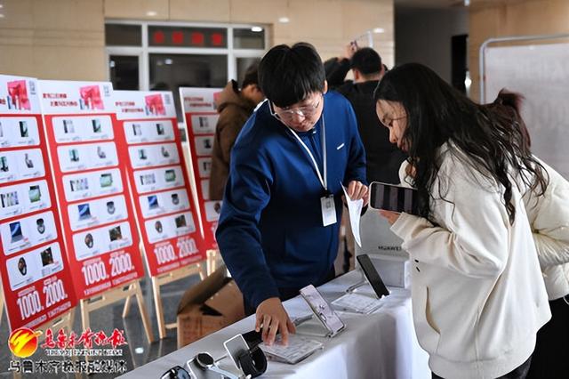 　　11月25日，在水磨沟区人民政府一楼大厅，机关干部职工在了解手机型号和价格。 记者雷婷摄