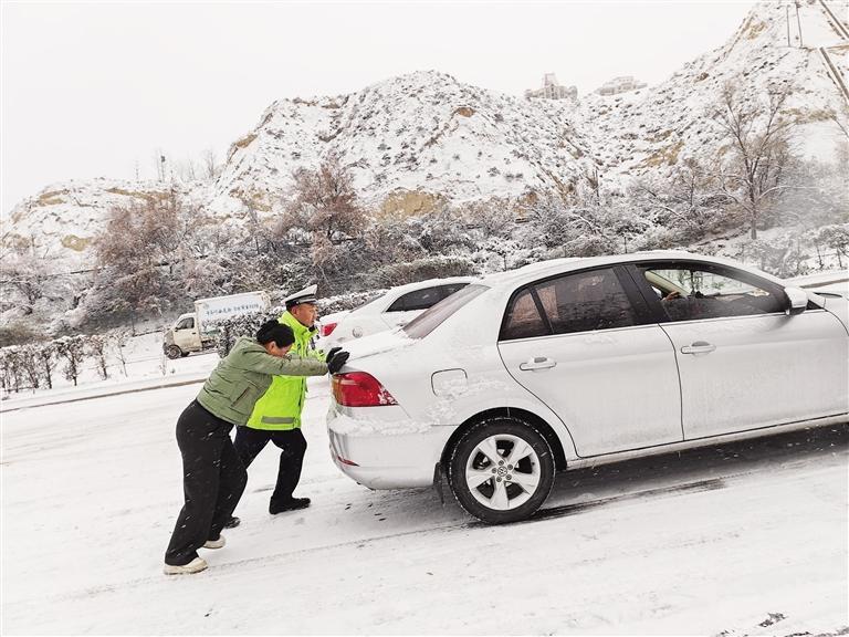 兰州交警冒雪帮助驾驶员推车 葛强 摄