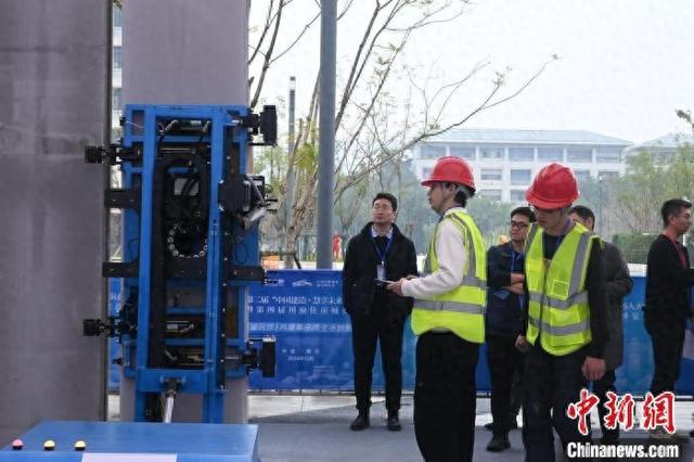 图为活动现场,工作人员在操作建筑机器人.张旭 摄