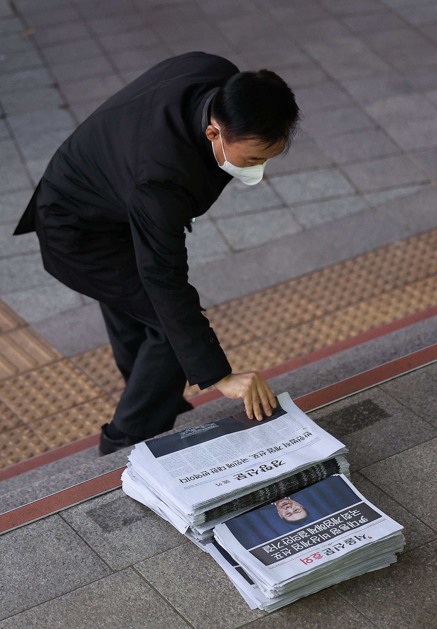 当地时间12月4日，韩国首尔，市民在光化门广场附近拿取有关解除紧急戒严令的公告。