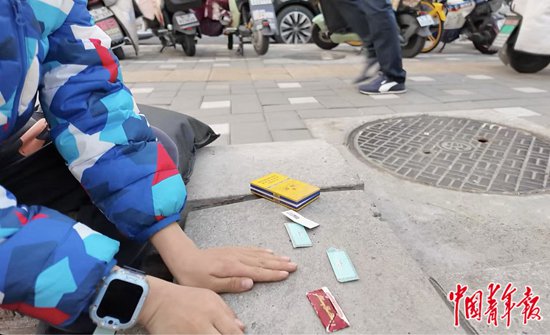 在北京市青年宫外一处空地前，小学二年级学生正在拍烟卡。中青报·中青网记者 谭思静/摄