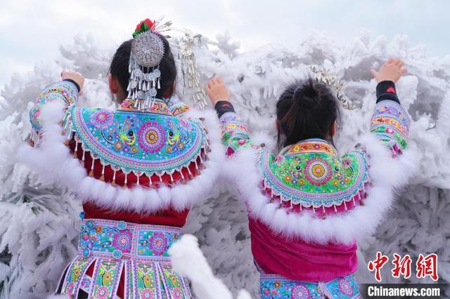 图为两位苗族女孩在雪中玩耍。梁强 摄