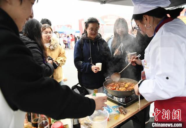 图为活动现场，大学生比拼厨艺引围观。中新社记者 周毅 摄