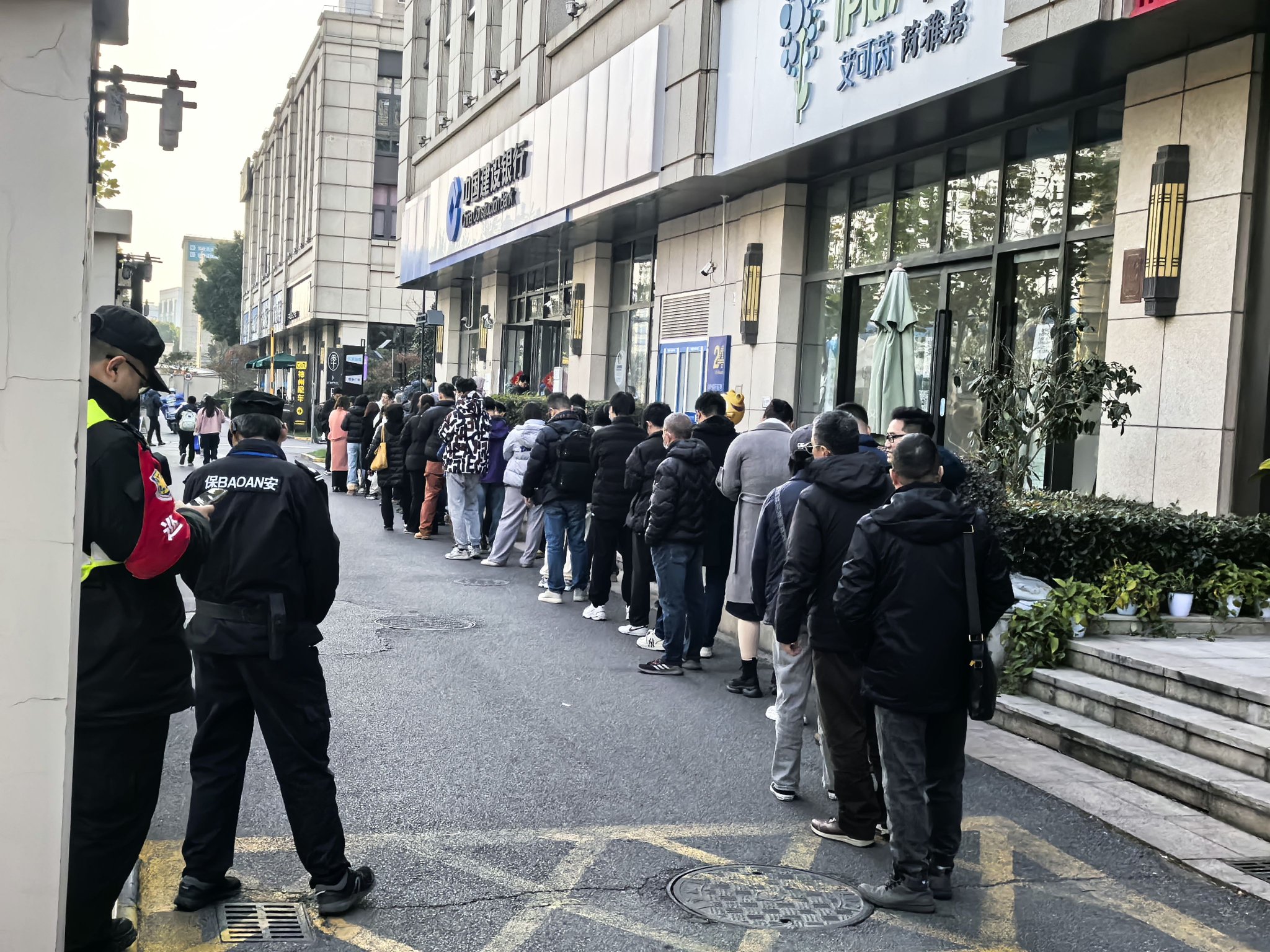 银行门口恭候兑换挂牵币、挂牵钞的长队,期间周报记者摄。