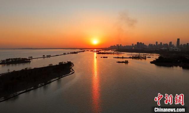 1月5日，正值小寒时节，安徽合肥巢湖岸边，夕阳倾洒余晖，晕染出一幅流动的水墨画卷。(无人机照片)中新社记者 韩苏原 摄