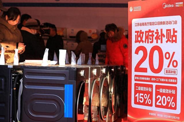 2024年12月21日,江苏省淮安市,市民在汽车家电家居迎新惠民集市购物消耗。 视觉中国 图