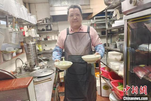 图为林洪程正准备给客人上菜。 (受访者供图)